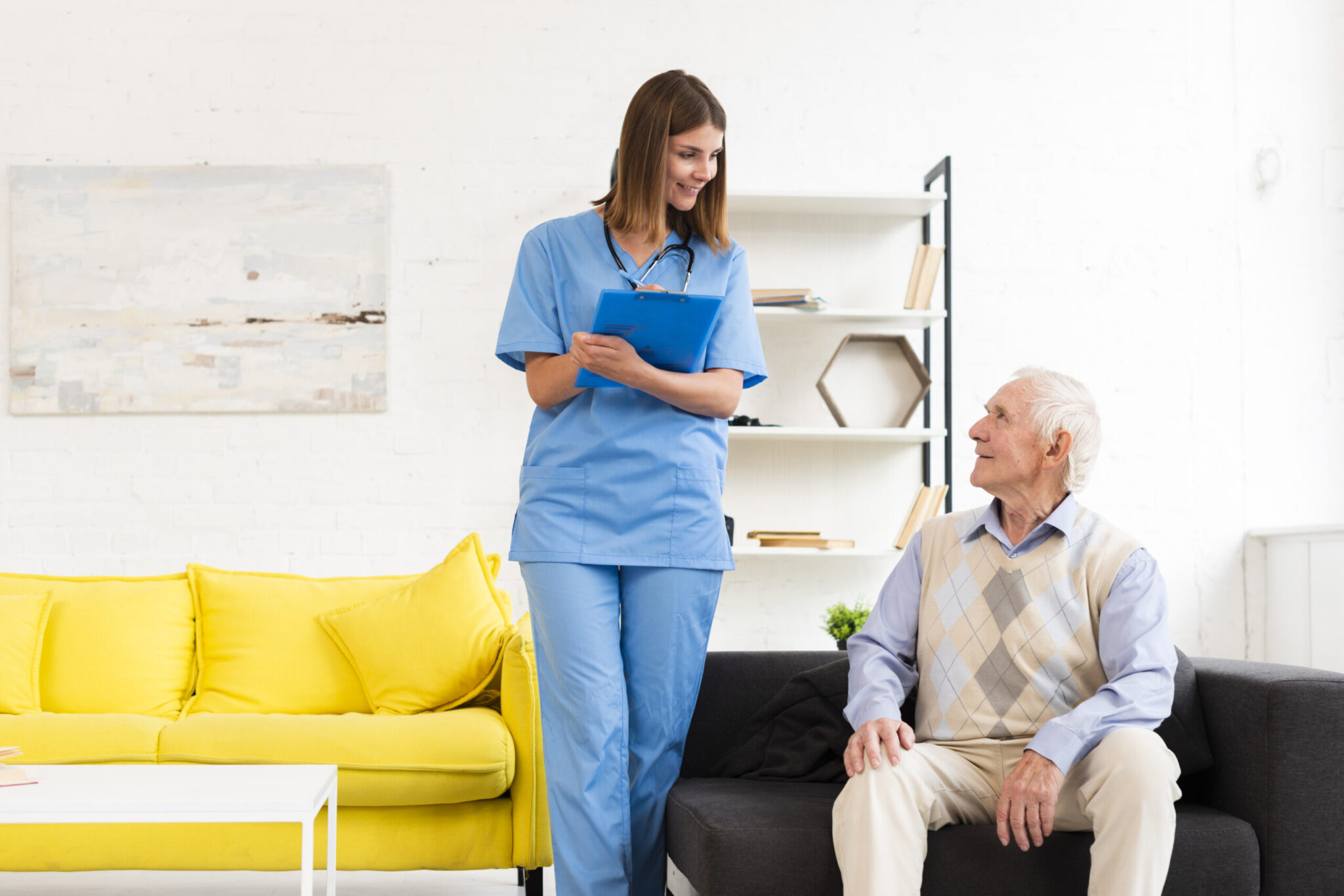 nurse-talking-old-man-sitting-black-sofa-scaled.jpg